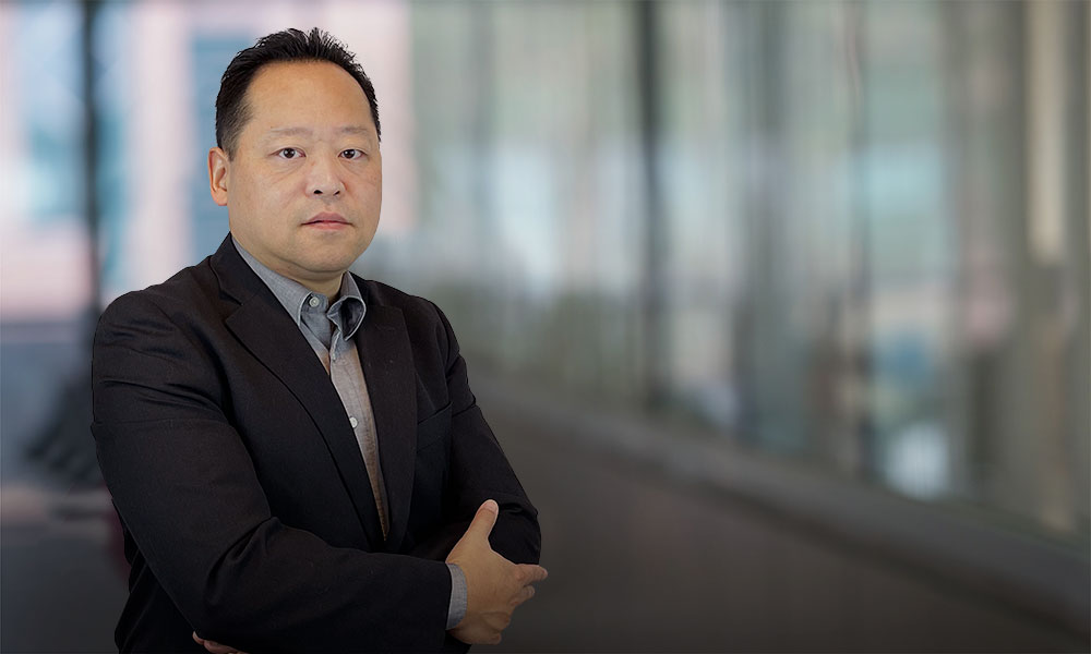 Julian Cheng, headshot with his arms crossed