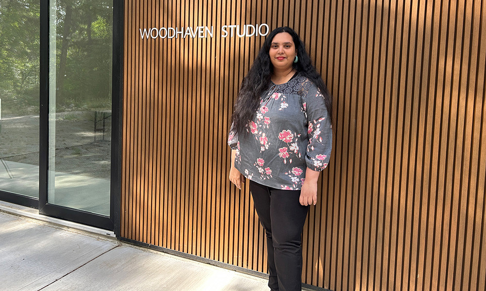 A woman stands in front of an art studio.